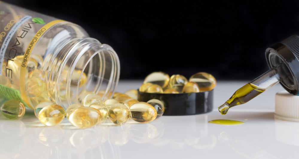 CBD oil capsules spilled from a bottle labeled 'MIRACLE' with 'CBD (Cannabidiol)' and a dropper releasing oil on a white surface