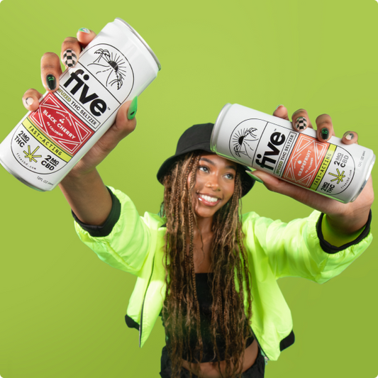 Smiling woman in a neon jacket and bucket hat holding two Five THC seltzer cans (Black Cherry and Grapefruit) against a bright green background