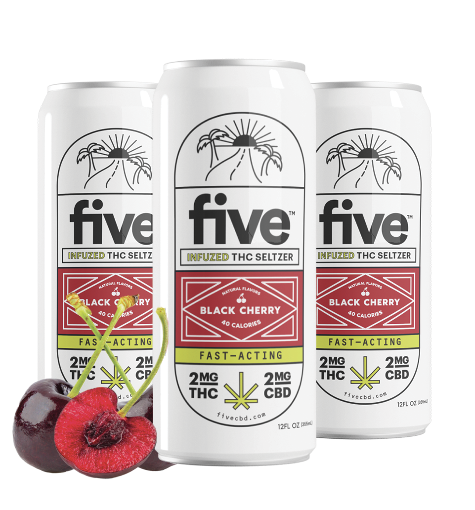 Three white 'five' energy drink cans with raspberries and pomegranate pieces